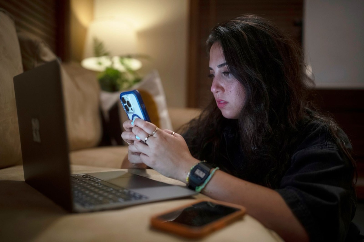 Roo Powell working a case on her phone and laptop at night